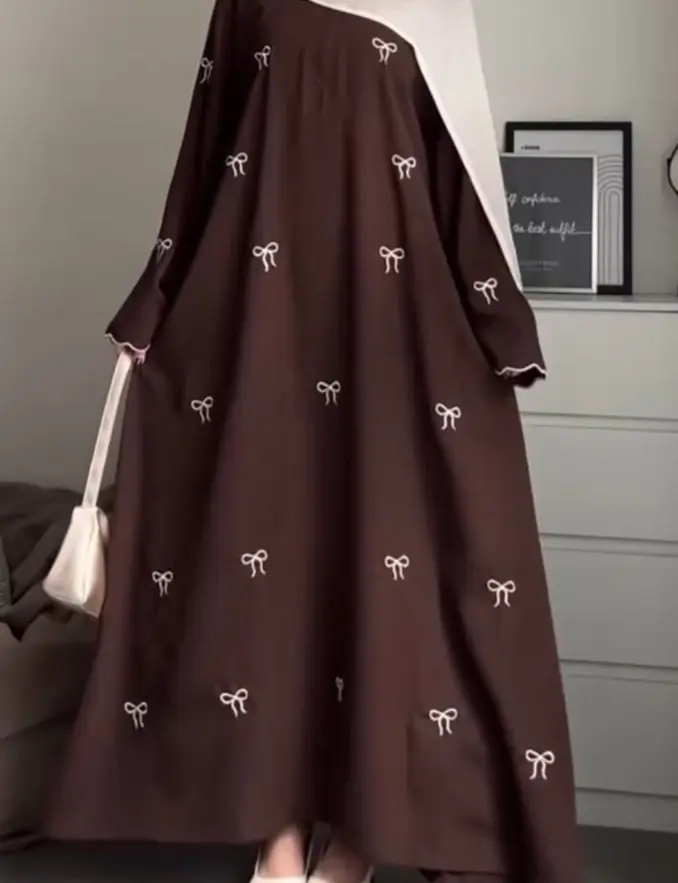 A woman wearing a brown abaya dress, representing cultural fashion with grace and modesty