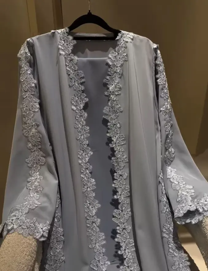 A gray abaya with intricate lace accents on the sleeves, showcasing a stylish design